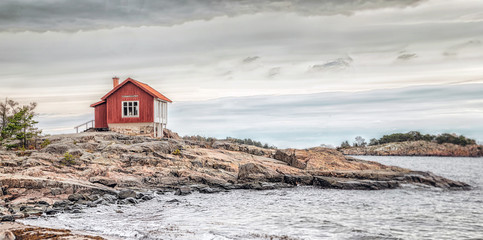 Red house at sea shore in dull colors at autumn - obrazy, fototapety, plakaty