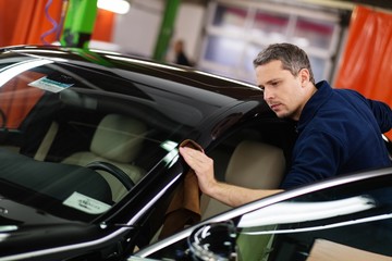 Man worker polishing car on a car wash