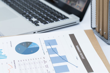 Analyzing investment charts with laptop. Accounting