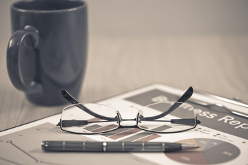 Business report. Cup of coffee and document.