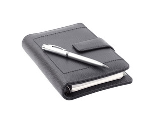 Note book with ballpoint pen on white background