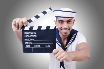 Sailor with movie clapper on white