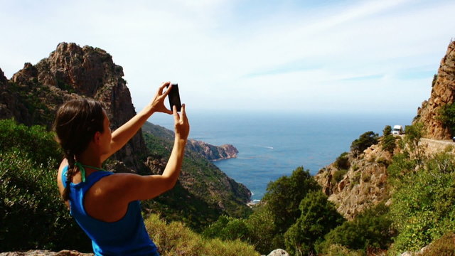 Woman taking picture of beautiful view in the sea