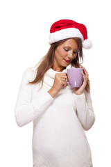 Cold young woman in a Santa hat sipping coffee tea