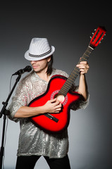 Man with guitar singing with microphone