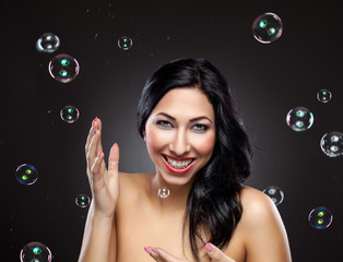 Young and happy woman surrounded by bubbles