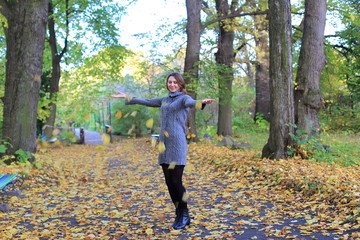 Cheerful woman enjoying autumn day in park