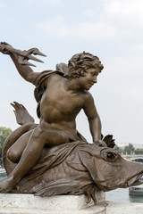 Paris - Sculpture of boy riding a fish on Pont Alexandre III
