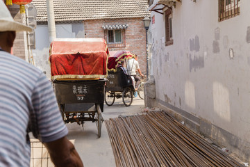 Beijing. Tourists ride on a pedicabs in the old town © Valery Rokhin