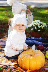 Baby boy with sister in autumn park