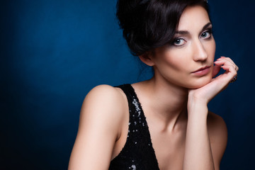 Fototapeta premium Portrait of beautiful brunette woman in black dress.