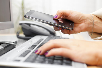 Woman is transferring application from computer to smart mobile