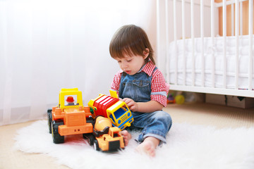 little boy plays cars at home