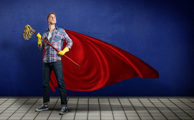 Student mit wischmopp in der Hand posiert wie ein Superheld