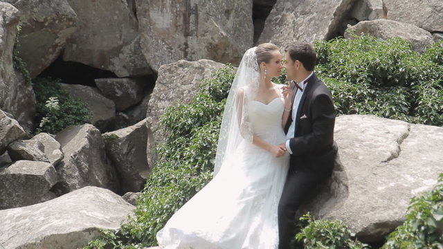 Newlyweds affectionate to each other among the rocks