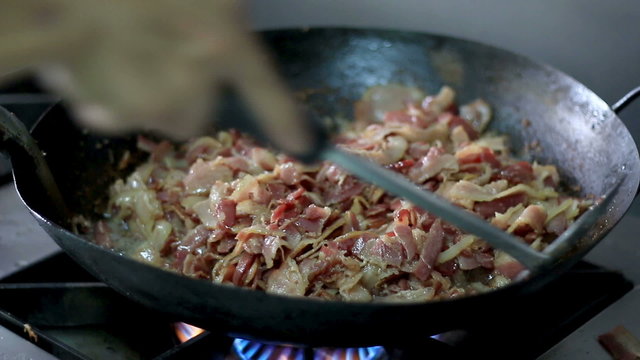 HD close up hand chef fried bacon in a pan