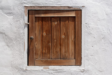 vintage wooden shutter in whitewashed wall