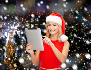 woman in santa helper hat with tablet pc