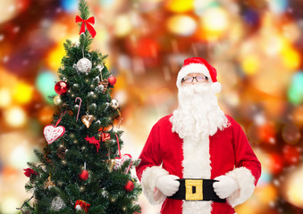 Fototapeta premium man in costume of santa claus with christmas tree