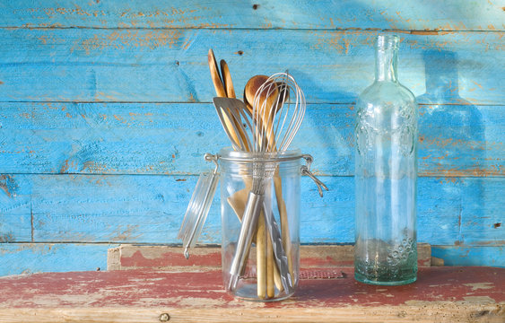 vintage kitchen utensils, wooden spoons and an old ornamented bo