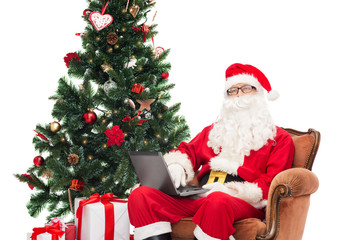 man in costume of santa claus with laptop