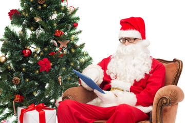 man in costume of santa claus with tablet pc