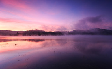 Fototapeta na wymiar Fog at dawn over the lake in the Bieszczady Mountains