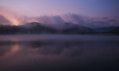 Fog at dawn over the lake in the Bieszczady Mountains