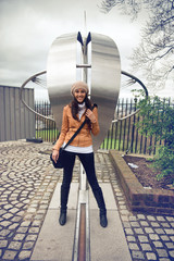 Smiling woman straddling the prime meridian line