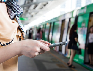 Woman using digital tablet at skytrain station