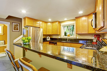 Maple kitchen cabinet with black granite tops