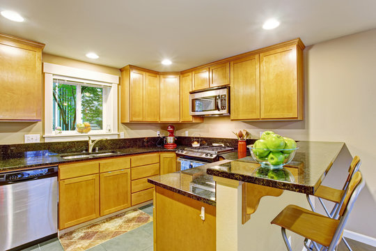 Maple kitchen cabinet with black granite tops
