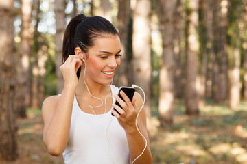 Young woman listening to music through earbuds