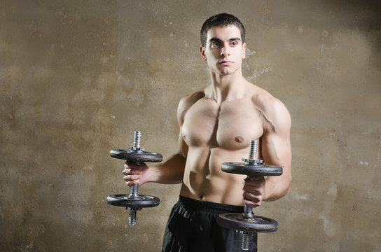 Man training shoulder muscles exercises in old gym