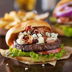 gourmet bacon and bleu cheese burgers with beer in background