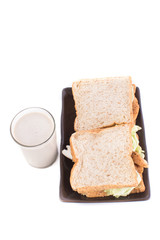 A meal of a sandwich and cold milk