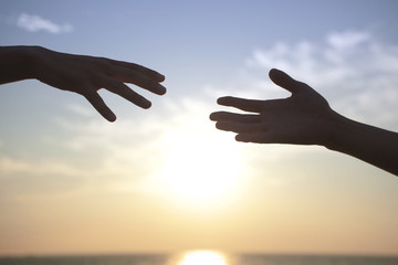 夕日と伸ばした2人の腕