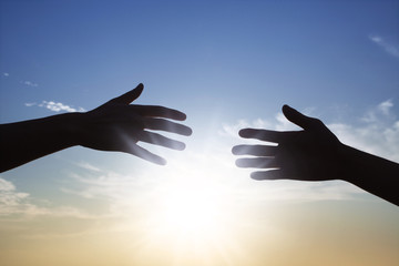 太陽の光と2人の手
