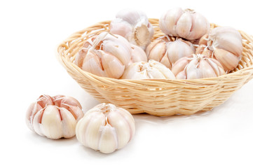 Fresh organic garlic in bamboo basket on white background