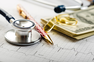 Dollars, stethoscope, pills and cardiogram. Costs for the medica