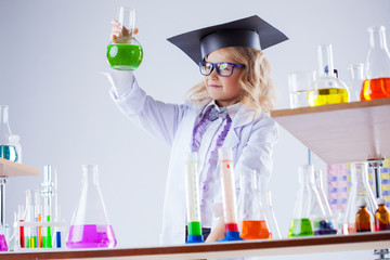 Young chemist posing with variety of reagents