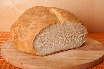 loaf of bread lying on a wooden board