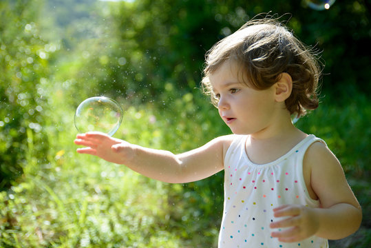 a little girl playing with soap bubbles