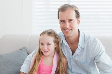 Casual father and daughter smiling at camera