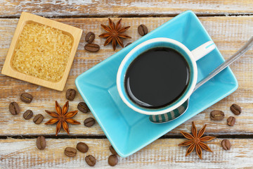Cup of black coffee, brown sugar, coffee beans and star anise