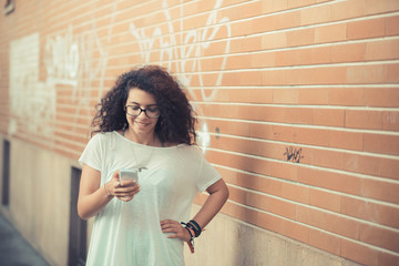 young beautiful moroccan curly woman using smartphone