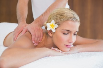Obraz na płótnie Canvas Woman receiving shoulder massage at spa center