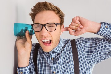 Geeky businessman eavesdropping with cup