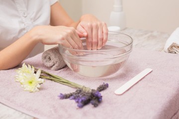 Obraz na płótnie Canvas Woman soaking her nails in water bowl