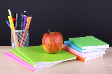 School supplies on table on dark background